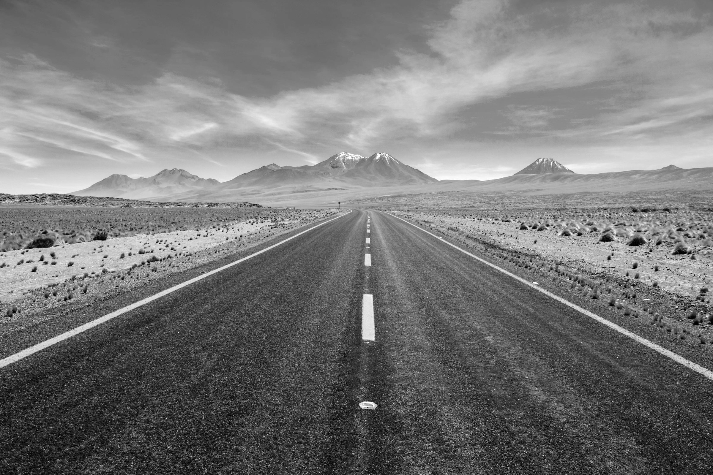 An open road running toward distant mountains